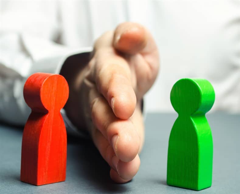 Hand seperating pieces in conflict representing Conflict Management course by Commerce Edge.